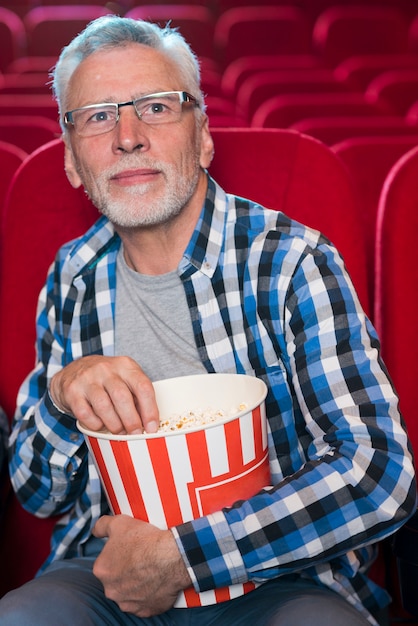 Oudere man kijkt naar film in de bioscoop