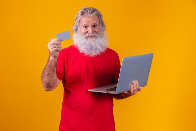 Oudere man met laptopcomputer en bankcreditcard. online winkelen transactie. mobiel bankieren cashless methode.