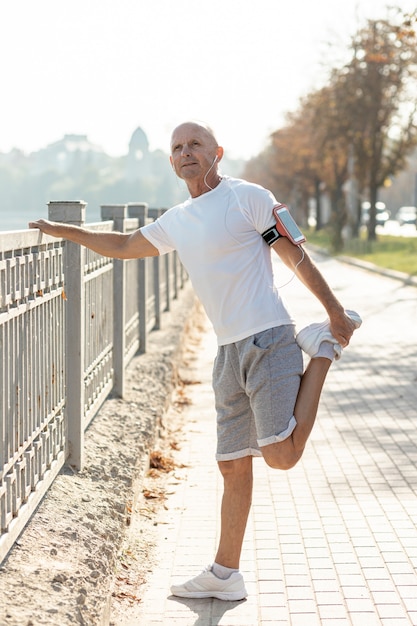 Oudere man runner die zich uitstrekt