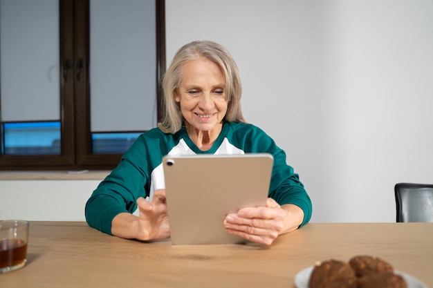 Oudere persoon die een digitaal apparaat gebruikt