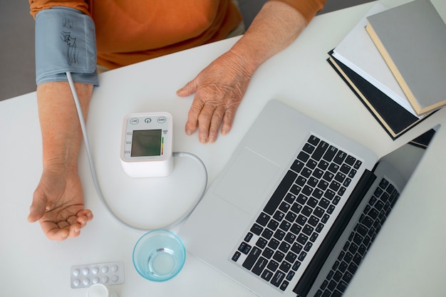 Oudere persoon die zijn bloeddruk controleert met een tensiometer