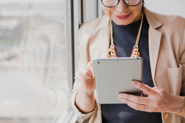 Oudere vrouw die een tablet houdt