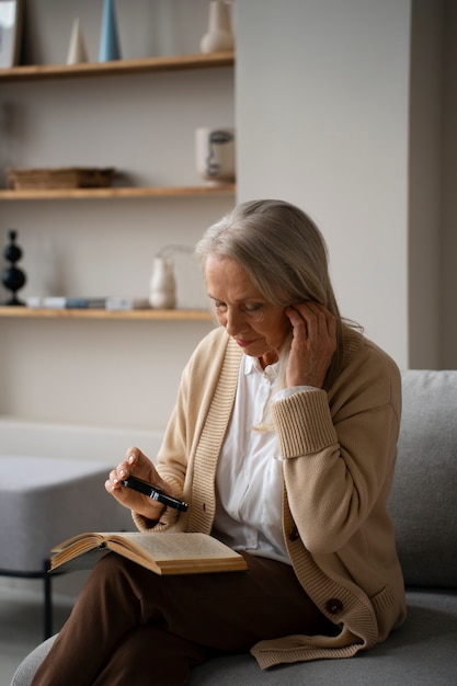 Oudere vrouw die een vergrootglas gebruikt om te lezen