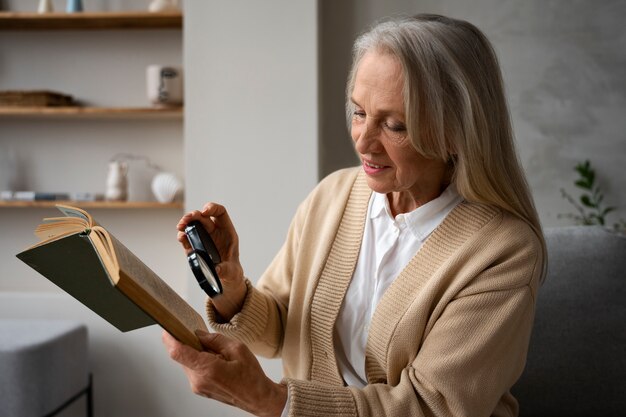 Oudere vrouw die een vergrootglas gebruikt om te lezen