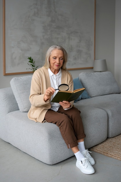 Oudere vrouw die een vergrootglas gebruikt om te lezen