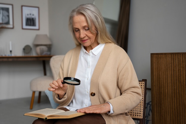 Oudere vrouw die een vergrootglas gebruikt om te lezen