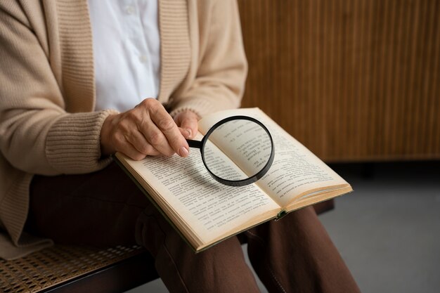 Oudere vrouw die een vergrootglas gebruikt om te lezen