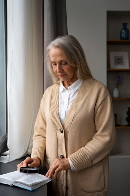 Oudere vrouw die een vergrootglas gebruikt om te lezen