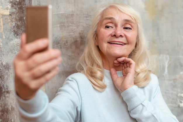 Oudere vrouw die selfie met mobiel nemen