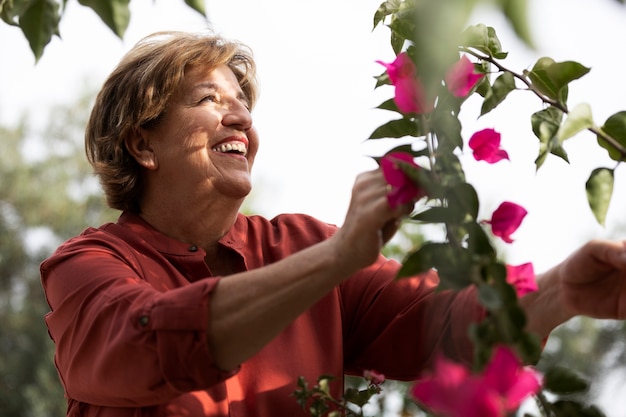 Oudere vrouw geniet van de natuur in haar landelijke tuin