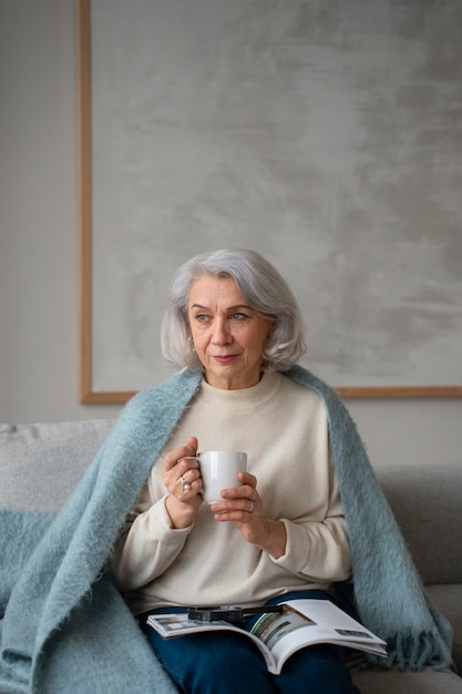 Gratis foto oudere vrouw leest terwijl ze een vergrootglas gebruikt