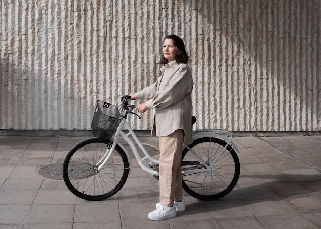 Oudere vrouw loopt met haar fiets