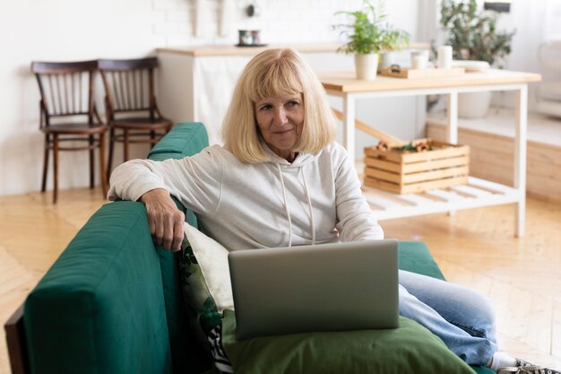 Oudere vrouw met laptop thuis
