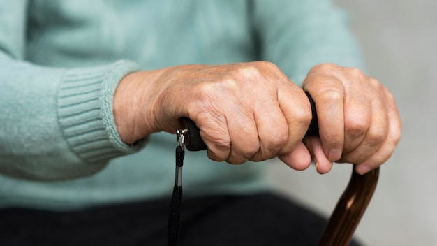 Gratis foto oudere vrouw met stok in handen