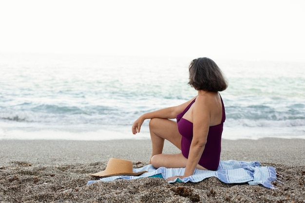 Oudere vrouw op het strand geniet van haar dag