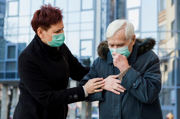 Oudere vrouwen met medische maskers ziek in de stad