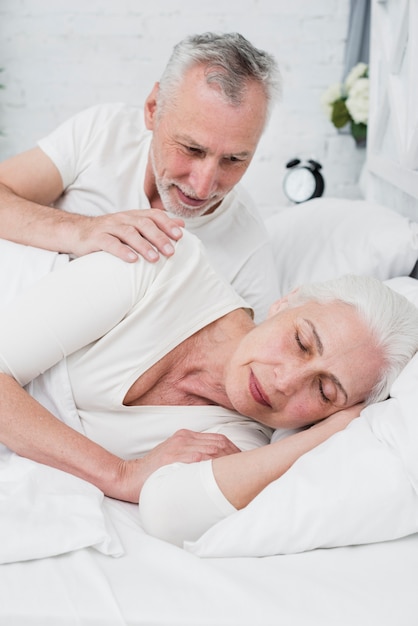 Oudere vrouwenslaap op een wit bed