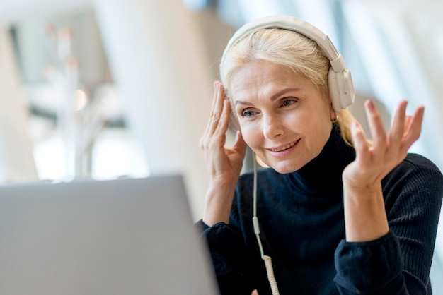 Oudere zakenvrouw met een videogesprek op laptop met koptelefoon