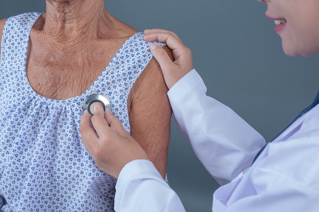 Ouderengezondheidscontrole met jonge verpleegster.