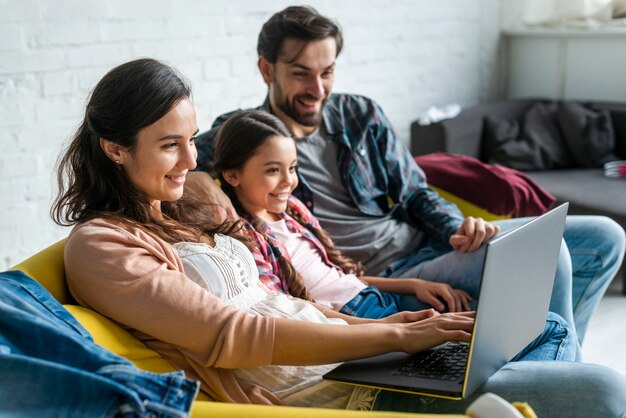 Ouders en dochter die laptop met behulp van