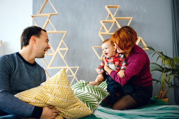 Ouders en hun dochtertje spelen met kussens op de vloer