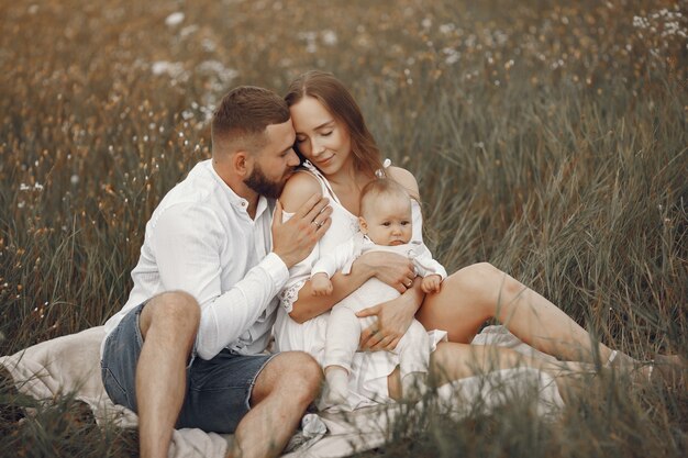 Ouders met dochter. Familie in een veld. Pasgeboren meisje. Vrouw in een witte jurk.