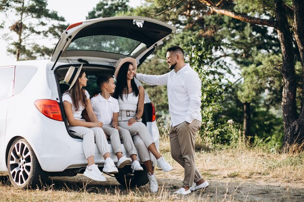 Ouders met hun kinderen op auto in het veld