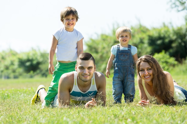 Ouders met kinderen die in het gras leggen