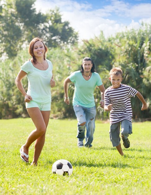 ouders met tiener zoon spelen met voetbal