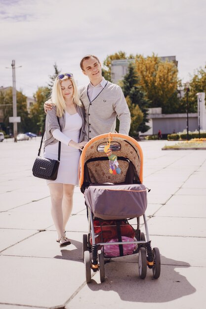 Ouders wandelen een kinderwagen