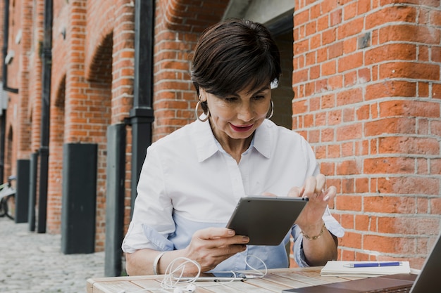 Oudste die een tablet in openlucht houdt