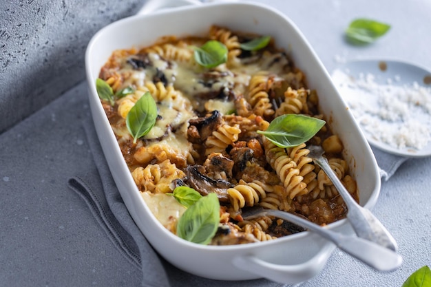 Gratis foto ovengebakken pasta met groenten, vlees en champignons in kom close-up