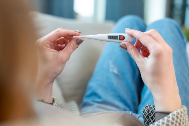 Over de schouder weergave vrouw en thermometer