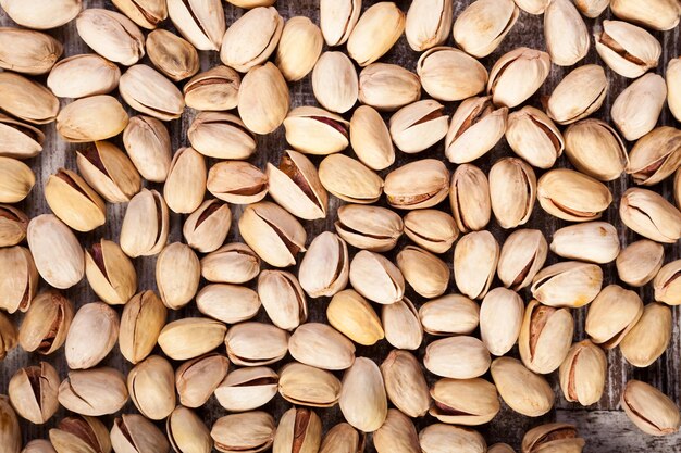 Over top close-up weergave van pistachenoten op houten achtergrond in studio foto. Gezonde heerlijke snacks