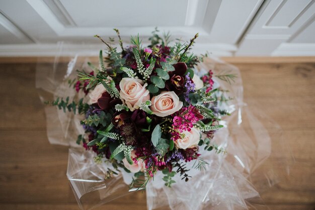 Overhead close-up shot van een bruiloft bloemboeket op een houten vloer