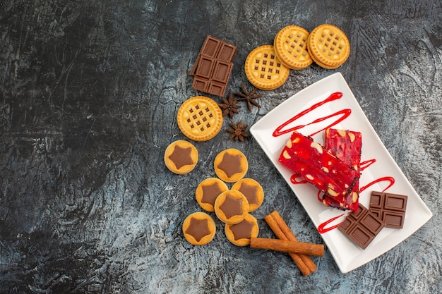 Overhead foto van koekjes en een bord chocolade op grijs