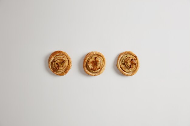 Overhead schot van smakelijke zoete swirl karamel vanillebroodjes klaar voor uw consumptie, geïsoleerd op een witte achtergrond. Heerlijk lekker dessert van bakkerswinkel. Bakkerijproducten zelfgemaakte taarten