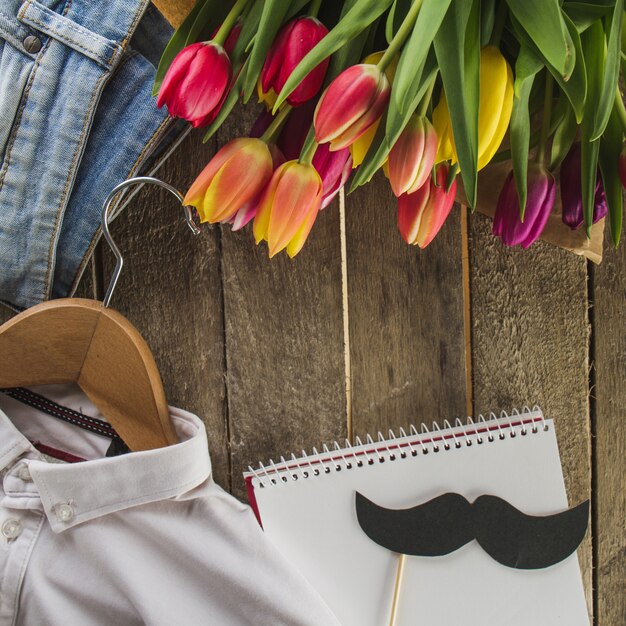 Overhemd, bloemen en notitieblok op planken voor vaderdag