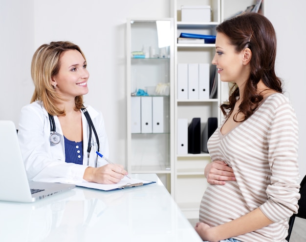 Overleg van jonge zwangere vrouw met haar arts