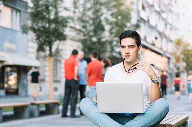 Overweegt jonge mensenzitting op bank met laptop