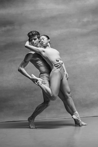 Paar balletdansers poseren over grijs
