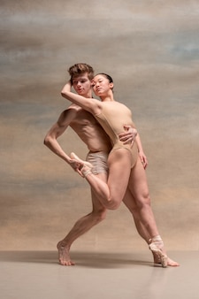 Paar balletdansers poseren over grijze ruimte