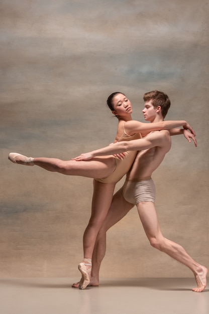 Paar balletdansers poseren over grijze ruimte