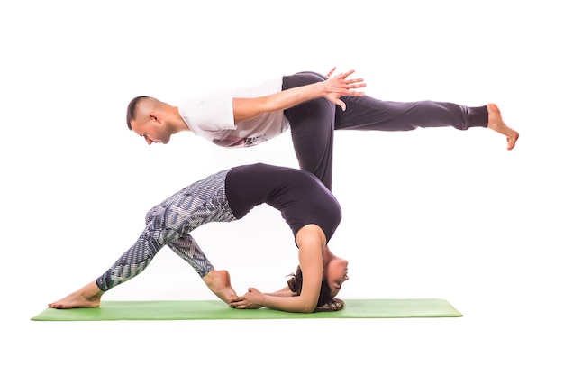 Paar beoefenen van acro yoga in witte studio. Acro yoga concept. Koppel yoga. Yoga flexibiliteit klasse training