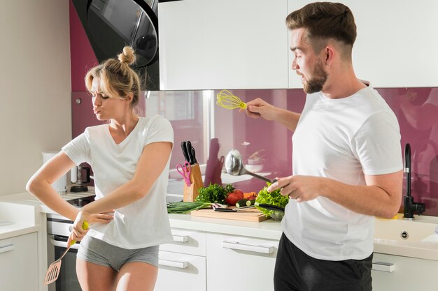 Paar binnenshuis gek rond in de keuken