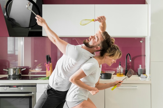 Paar binnenshuis zingen in de keuken zitten in zijaanzicht