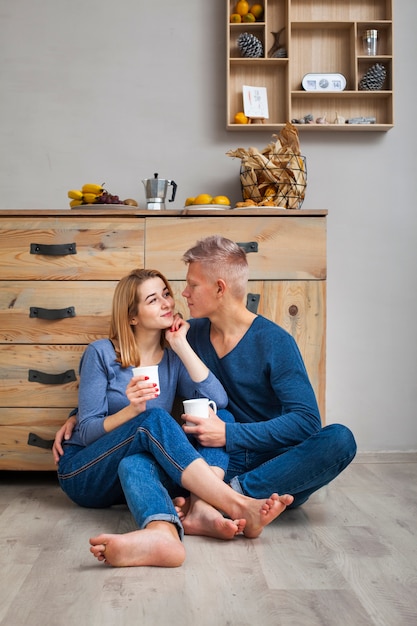 Paar dat een kop van koffie op de vloer heeft