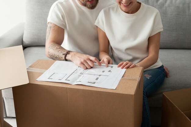 Paar dat huisplan bespreekt, zich in nieuw huis beweegt, vernieuwing plant