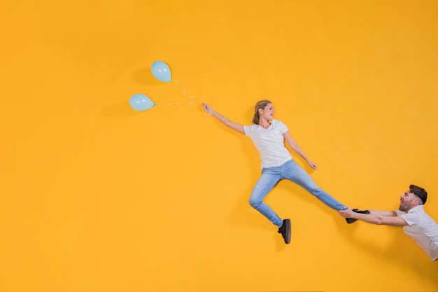 Gratis foto paar dat in de lucht met ballons drijft