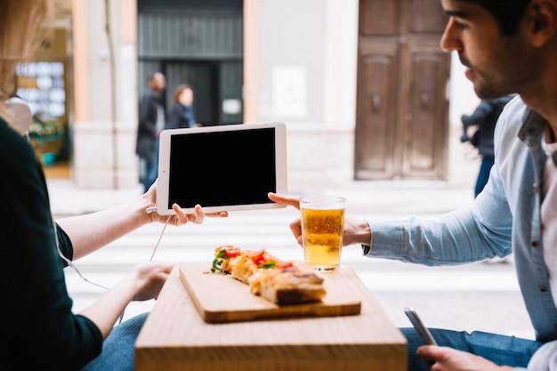 Paar die tabletzitting in restaurant gebruiken